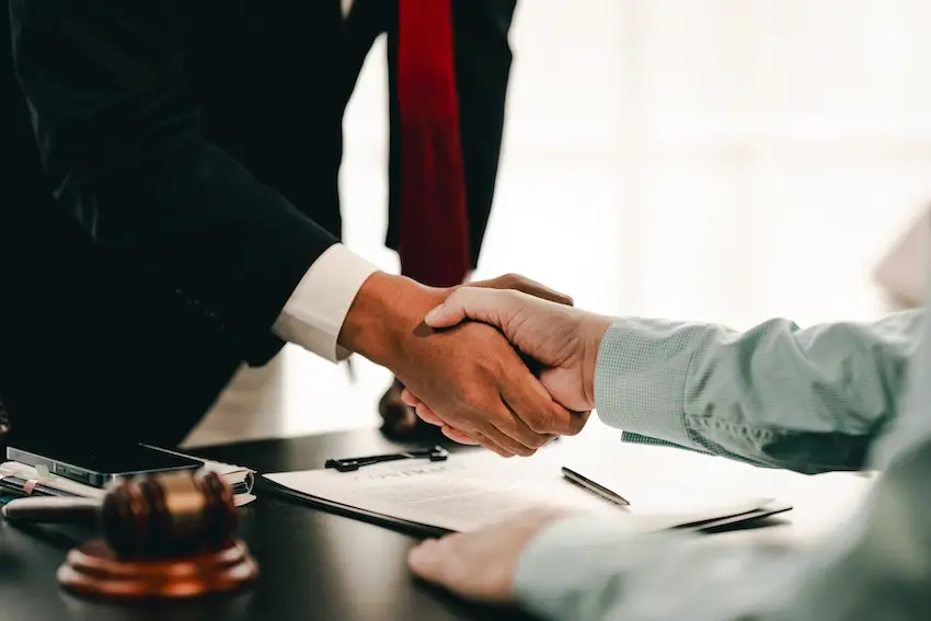 A personal injury lawyer shaking hands with a client for a personal injury case.
