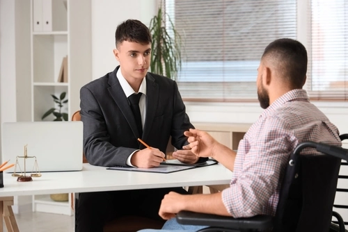 A man in a wheelchair meets a catastrophic injury lawyer in Greenwood, South Carolina.