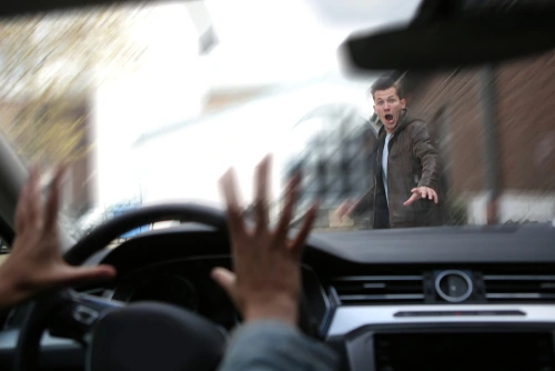 A vehicle speeds toward a man walking who needs a pedestrian accident lawyer.