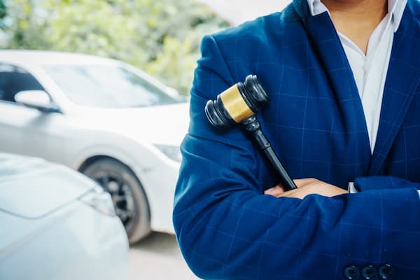A South Carolina car accident lawyer stands beside a vehicle holding a gavel.