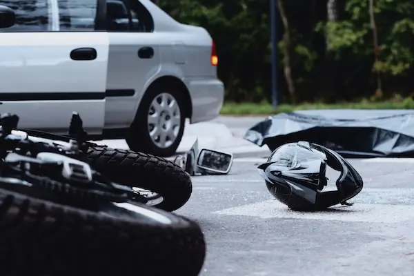 Injured motorcyclist beside a damaged motorcycle after a crash