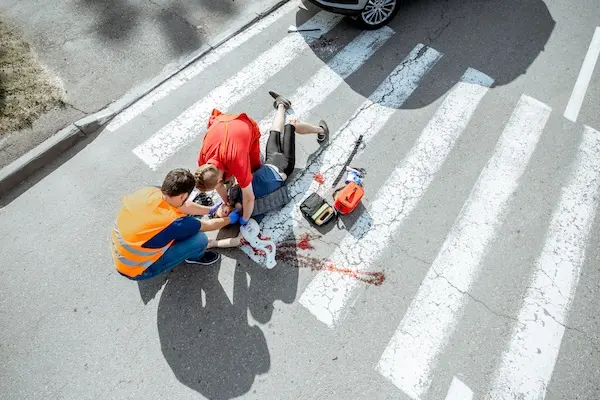 Injured pedestrian receiving medical treatment after a collision